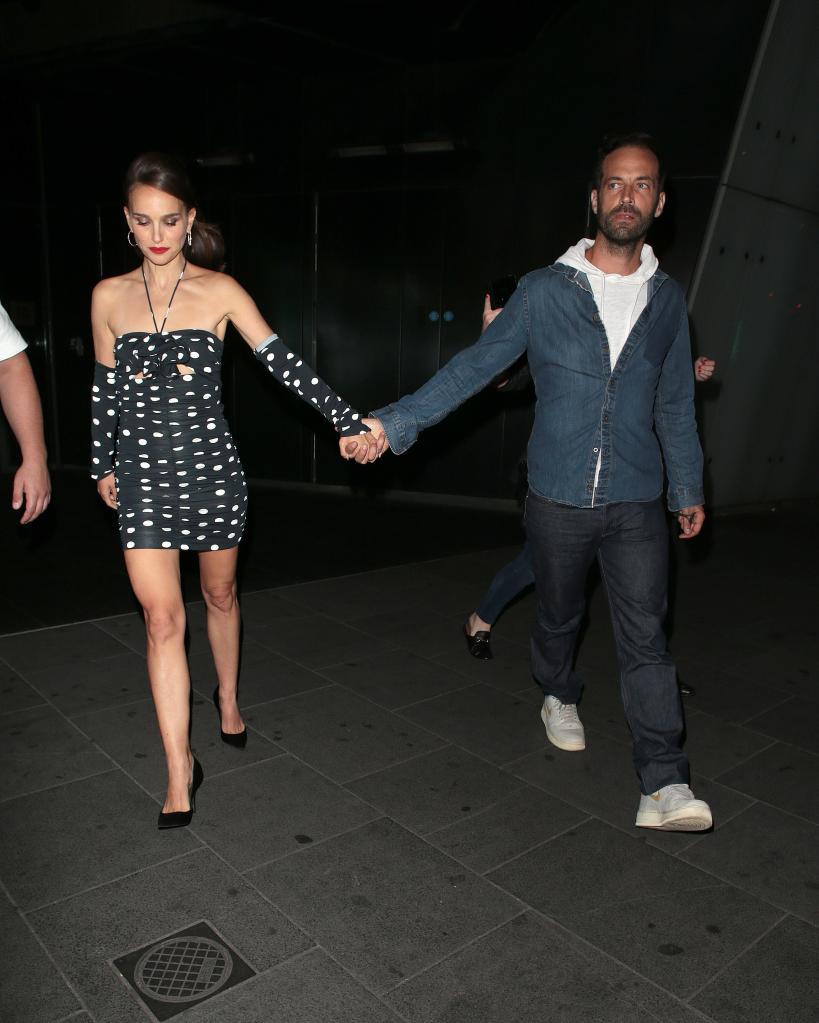 Natalie Portman and Benjamin Millepied holding hands while walking apart from each other.