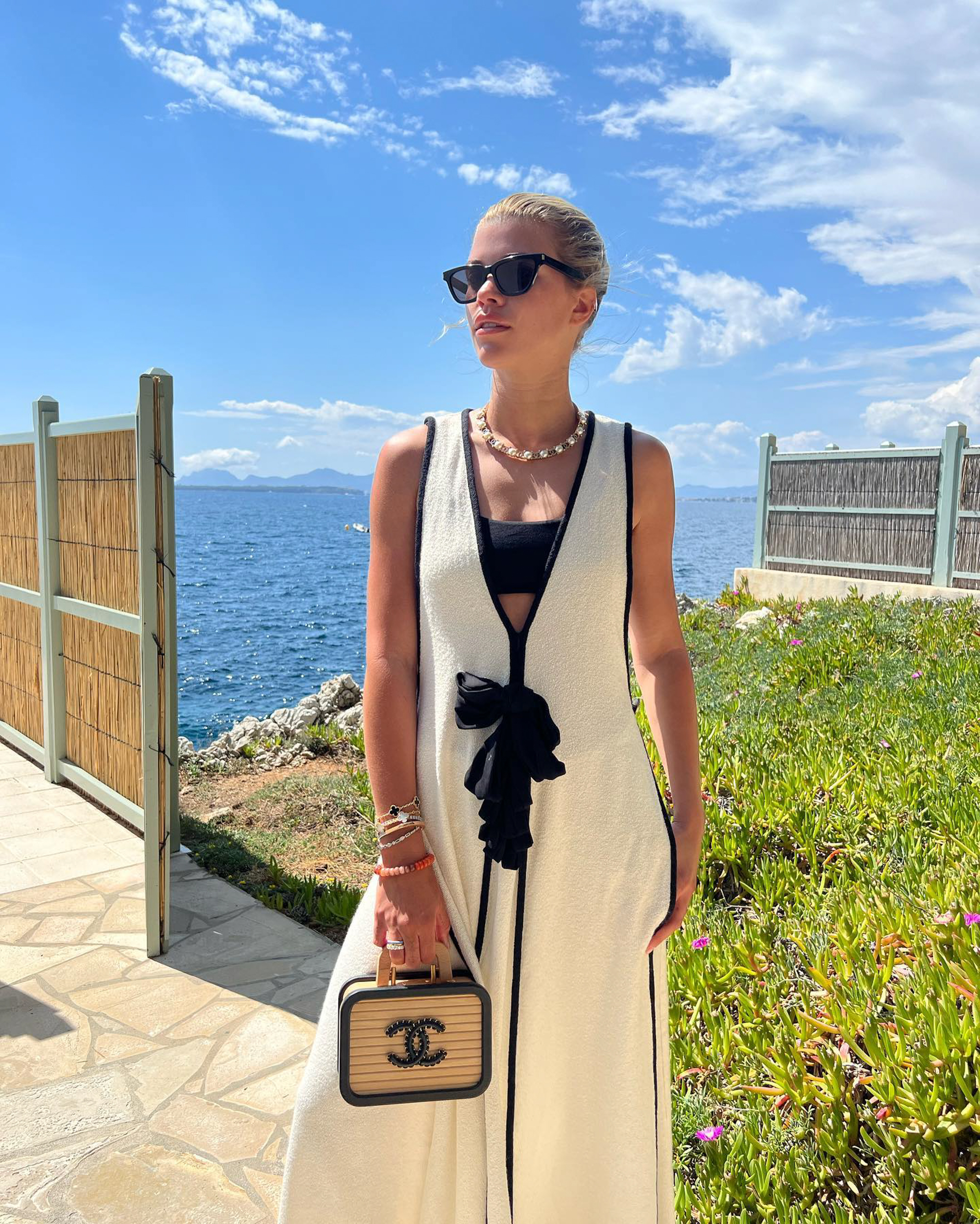 Sofia Richie in a white dress carrying a Chanel bag